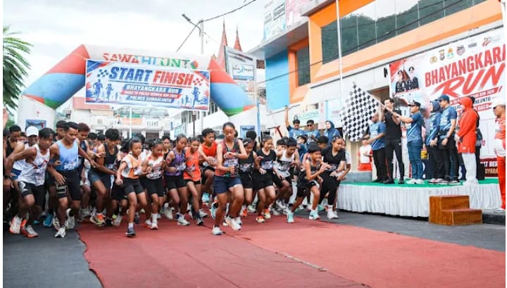 Ribuan pelari memadati garis start Bhayangkara Run Road to Police Woman Run 2026 di Kota Tua Sawahlunto, Minggu (12/7/2026).  